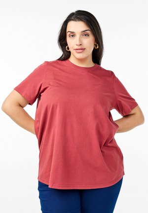 Camiseta de manga corta casual en color rojo ladrillo, hecha de algodón suave, con un corte holgado y un cuello redondo. Textura suave con aberturas laterales.