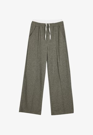 Graue Hose mit weitem Bein und vertikalen weißen Streifen. Elastischer Bund mit Kordelzug. Seitentaschen. Weicher Stoff.