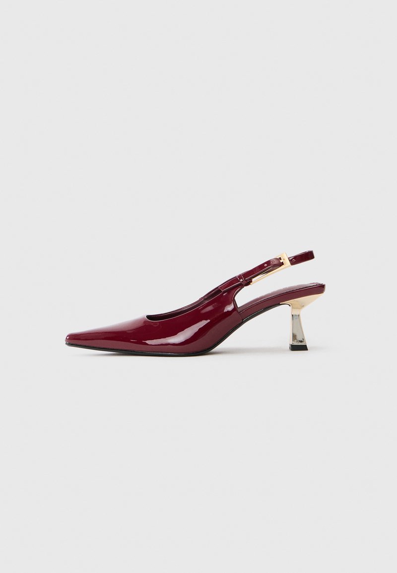Sjajna burgundska slingback cipela s oštrim vrhom, zlatnim kopčanjem i srednje visokom metalnom blok petom na bijeloj pozadini.