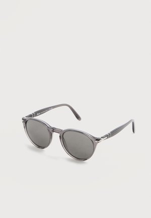 Round gray-tinted sunglasses with translucent gray plastic frame and slightly curved temples on a white background.