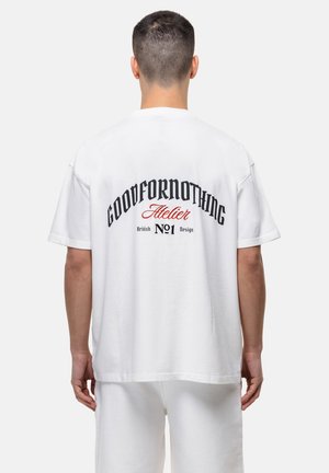 White cotton t-shirt with a relaxed fit, featuring black and red printed text on the back that reads "GOODFORNOTHING Atelier British No1 Design."