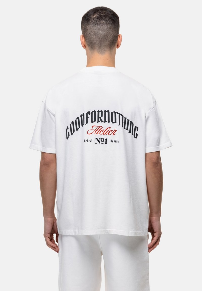 Witte katoenen t-shirt met een ontspannen pasvorm, met zwarte en rode bedrukte tekst op de achterkant die leest: "GOODFORNOTHING Atelier British No1 Design."
