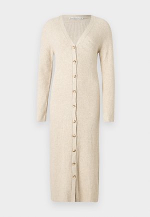 Bézs színű, bordázott hosszú kardigánruha hosszú ujjal és végigfutó elülső gombolással.