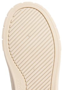 Beige gummisul med horisontella ränder, cirkulära detaljer och strukturerat greppmönster. Släta kanter med rundad form.