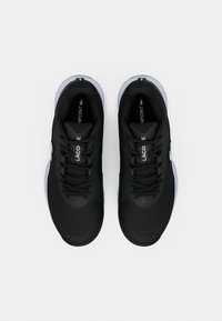 Czarne buty sportowe z fakturowaną cholewką, płaskimi sznurowadłami i białą podeszwą. Na boku znajduje się detal z logo oraz przeszycia na czubku buta.