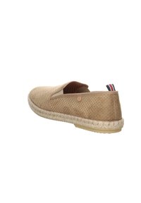 Zapato slip-on perforado beige con suela de cuerda de yute, puntera redondeada y pequeño detalle de logo en el tacón. Textura suave con un diseño casual.