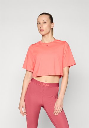 Coral cropped athletic top with short sleeves, featuring a small logo. Paired with high-waisted, berry-colored leggings displaying brand name.
