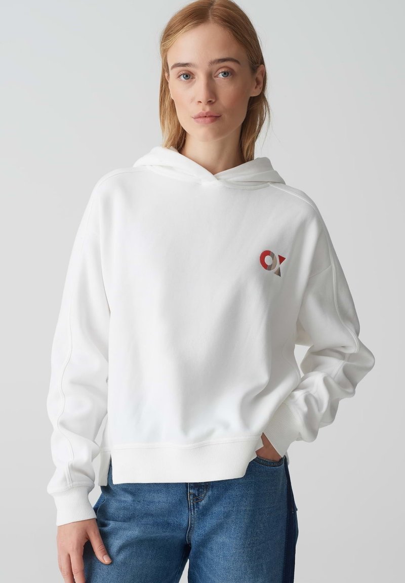 Felpa bianca in cotone con tasca frontale e dettaglio del logo rosso e rosso scuro sul lato sinistro del petto. Presenta una vestibilità comoda e polsini a coste.