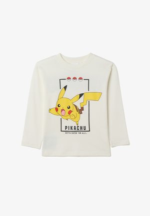 Long-sleeve cream cotton t-shirt featuring a graphic of Pikachu. Design includes text "Pikachu" and Poké Balls above the character.