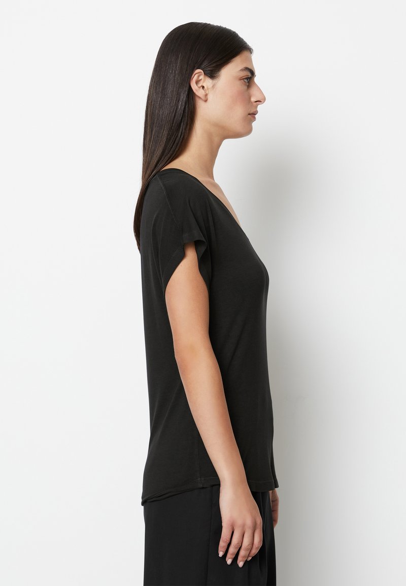 Schwarzes T-Shirt mit kurzen Ärmeln und V-Ausschnitt, glatte Textur, leicht lockere Passform und abgerundetem Saum. Trägt man zu fließenden schwarzen Hosen.