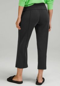 Czarne, krótkie spodnie sportowe z teksturowanym wykończeniem, z kontrastującymi szwami po bokach, elastycznym pasem i wywiniętym wykończeniem dołu.