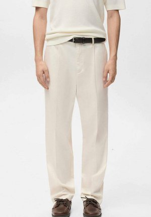 Pantalon taille haute de couleur crème à coupe droite, doté d'une fermeture éclair à l'avant, de poches latérales et d'une texture lisse. Porté avec une ceinture noire.