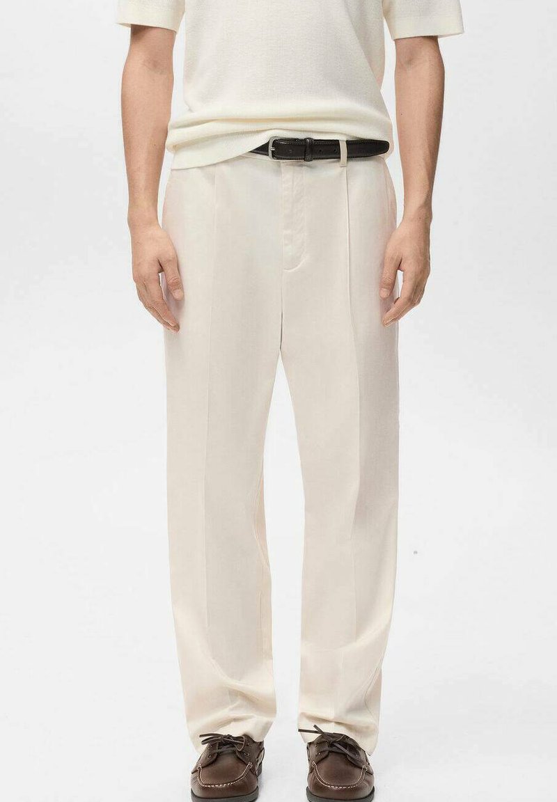 Kremowe spodnie z wysokim stanem o prostym kroju, posiadające przedni zamek, boczne kieszenie i gładką fakturę. Noszone z czarnym paskiem.