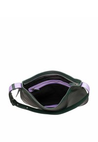 Groene leren schoudertas met een lila hengsel. Het interieur heeft een zwarte voering en een paarse ritszak. Soepele textuur, ruime indeling.