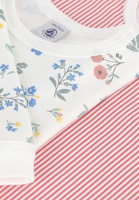 White cotton fabric with blue and yellow floral patterns paired with red and white striped fabric, featuring a soft, smooth texture.