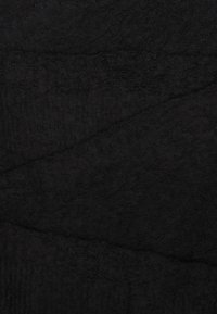 Tissu noir texturé avec une surface douce, présentant un motif abstrait subtil. Le matériau semble épais et moelleux.