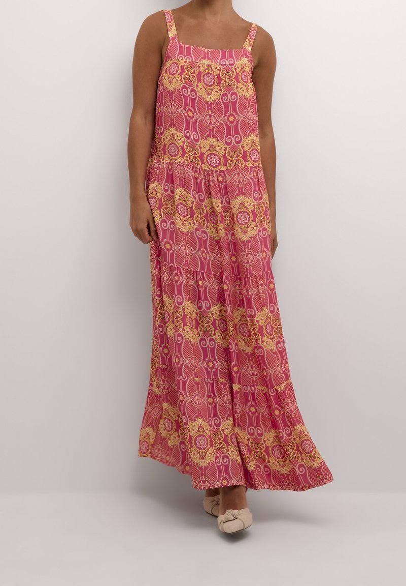 Long pink dress with yellow ornate patterns, square neckline, and thin shoulder straps, flowing and slightly textured fabric.