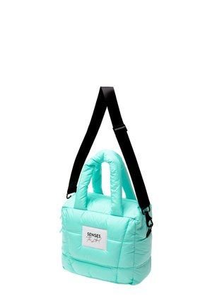 Hellblaue gesteppte Handtasche mit gepolsterten Griffen, schwarzem verstellbarem Schulterriemen und vorderem Etikett mit der Aufschrift "Senses The Label."
