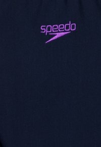 Tessuto per costumi da bagno blu navy con logo "speedo" viola; texture liscia senza motivi; design minimalista incentrato sull'identificazione del marchio.