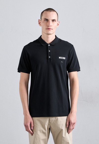 Sort polo shirt lavet af glat bomuld, med en klassisk krave, tre-knaps lukning og et hvidt "Moschino" logo på venstre bryst.