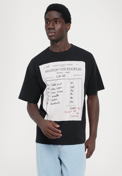 T-shirt en coton noir avec un design graphique blanc comportant des textes et des chiffres imprimés, des manches courtes et une coupe décontractée.