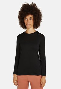 Schwarz langärmliges T-Shirt aus weichem Stoff, mit rundem Halsausschnitt und taillierter Passform, kombiniert mit hellen Hosen.