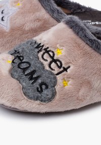 Pantuflas de felpa rosa con acentos grises; presentan un bordado de nube gris con "Conoce Sueños", estrellas amarillas y un tejido suave y texturizado.