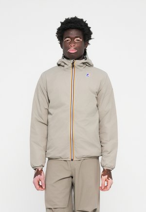 Veste zippée beige clair avec capuche, dotée d'une bande verticale multicolore, de poignets élastiques et d'un logo sur la poitrine gauche.