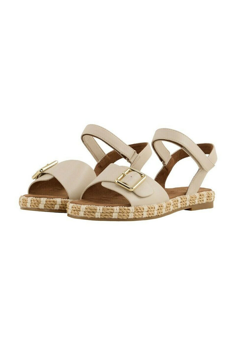 Beige Sandalen mit flacher Sohle, ausgestattet mit einem breiten Riemen und goldener Schnalle. Geflochtene Juteborte entlang der Sohle sorgt für Textur.