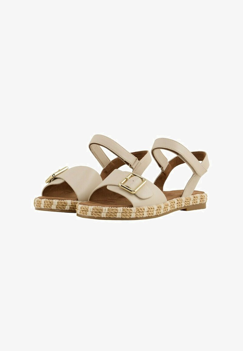 Beige Sandalen mit flacher Sohle, ausgestattet mit einem breiten Riemen und goldener Schnalle. Geflochtene Juteborte entlang der Sohle sorgt für Textur.