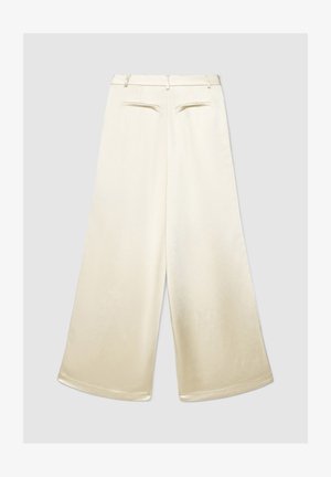 Pantalon à jambes larges en tissu beige clair à texture lisse. Présente un avant plat, des passants de ceinture et deux poches arrière.