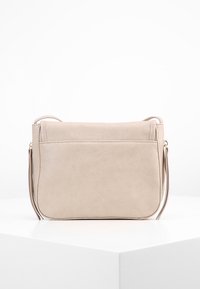 Beżowa syntetyczna torba na ramię o gładkiej fakturze, smukłym prostokątnym kształcie, z zamkiem błyskawicznym i regulowanym paskiem na ramię.