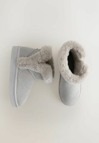 Graue Wildleder-Stiefeletten mit weichem Futter aus Kunstfell, mit einem umgeschlagenen Kragen und einer strukturierten Gummisohle. Das Design zeichnet sich durch eine minimalistische Form aus.