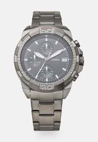 Chronograph-Uhr mit einem grauen Metallarmband und einem dunkelgrauen Zifferblatt. Zu den Merkmalen gehören drei Unterzifferblätter, silberne Akzente und eine auffällige Lünette.