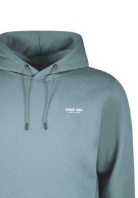 Hoodie in gedempt teal stof, met een trekkoord en witte tekstprint "SINCE 1982" op de linkerborst. Glad oppervlak.