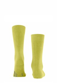 Gelbe Knöchelsocken aus weichem Material, mit gerippten Bündchen und einem schlichten Design, das ein gedrucktes Logo an der Seite aufweist.