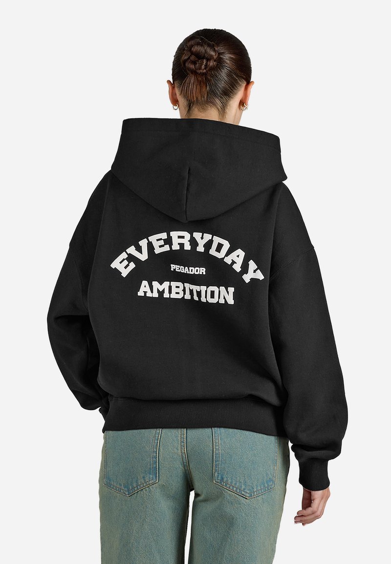 Felpa nera con cappuccio che presenta un testo bianco sul retro che dice "EVERYDAY AMBITION" con "PEGADOR" sottostante. Vestibilità casual, polsini e fondo a costine.