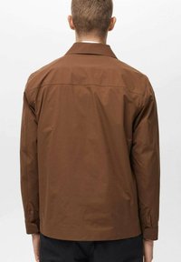 Brown, long-sleeve jacket with a classic collar and straight-cut design. Smooth texture, minimal stitching details, and a simple back seam.