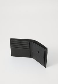 Portefeuille bifold noir en cuir ouvert montrant plusieurs emplacements pour cartes et un compartiment à pièce à bouton-pression sur une surface blanche.