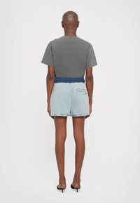 Grå bomulls t-skjorte med korte ermer, kombinert med lyseblå denimshorts med blå elastisk midje og baklomme.