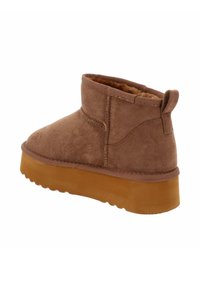 Stivale alla caviglia in suede marrone con fodera morbida, punta rotonda e suola in gomma. Presenta un dettaglio cucito e un secondo di presa sul tallone.