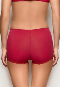 Røde boyshorts med blonder, lavet af glat, strækbart materiale med et tætsiddende design, der viser en sømløs ryg og delikate bølgede kanter.