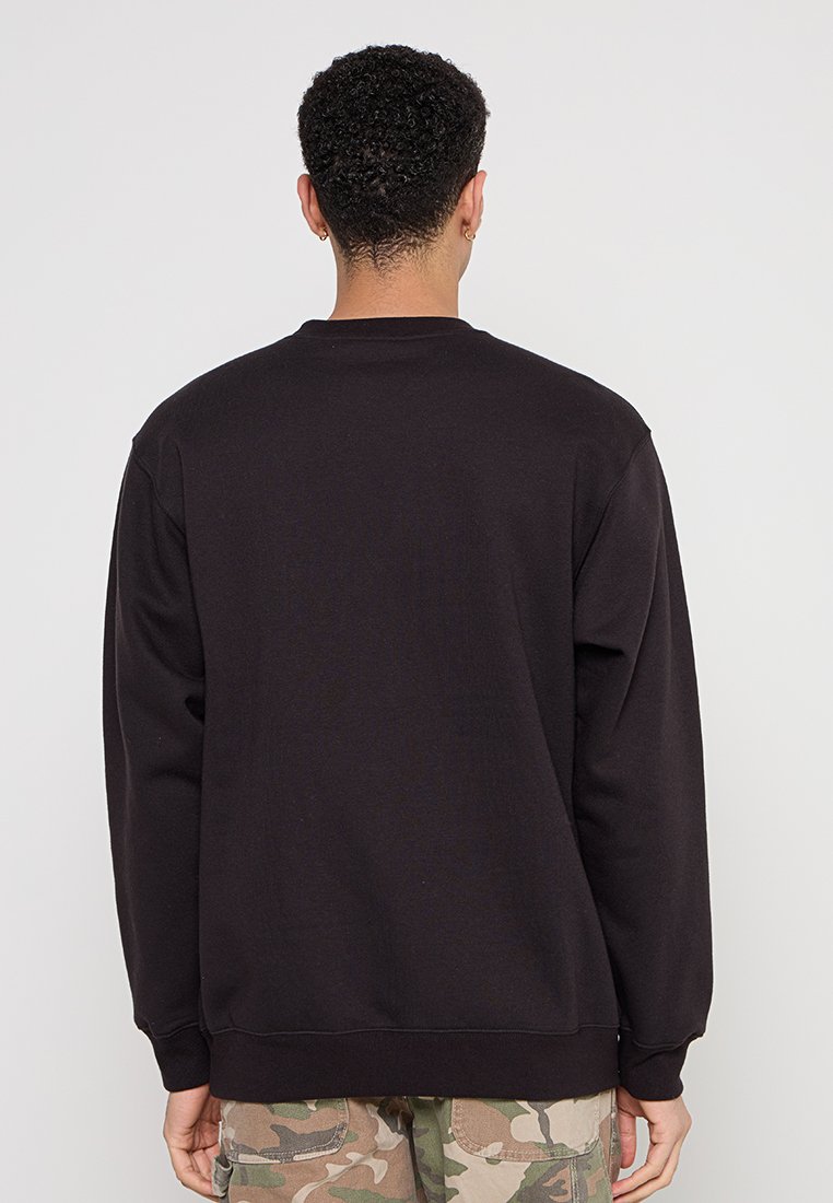 Felpa nera con collo rotondo, maniche lunghe e polsini a costine, realizzata in un tessuto testurizzato. Progettata con un retro semplice.