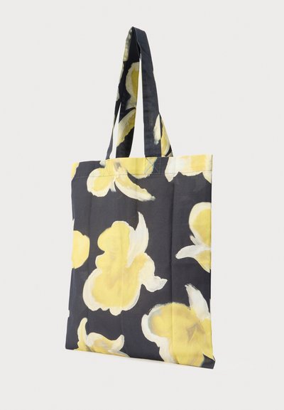 Tita kott tume taustaga ja suure kollase lillemustriga. Valmistatud kangast, varustatud kahe tugevate kandekäepidemega.