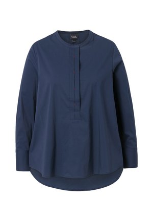Marineblaues Langarmshirt mit runden Ausschnitt, das eine gefaltete Vorderseite und kontrastierende rote Nähte aufweist. Hergestellt aus weichem, leichtem Stoff.