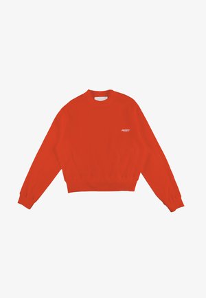 Czerwony sweter z prążkowanym splotem, okrągłym dekoltem i długimi rękawami. Charakteryzuje się krótszym krojem oraz niewielkim białym logo "PROSTO" na przodzie.