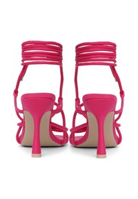 Rosa High Heels Sandalen mit mehreren Riemendetails, schlanker Absatz, glatter Textur und offener Rückseite. Mit einer dezenten beigen Sohle.