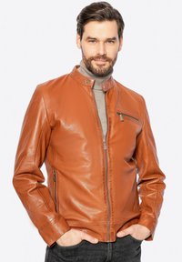 Giubbotto di pelle marrone con collo rialzato, zip frontale e tasche laterali. Caratterizzato da una texture liscia e un design aderente.