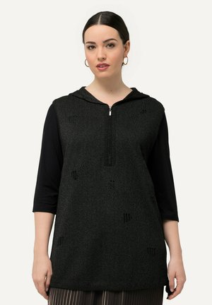 Tunic nera in maglia con chiusura lampo frontale, cappuccio e maniche a tre quarti. Presenta un sottile motivo testurizzato su tutta la superficie.
