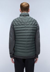 Grüne isolierte Weste mit horizontal gestepptem Design, hohem Kragen und grauen Pulloverwaren. Verfügt über eine strukturierte Oberfläche und dezente Markenkennzeichnung.